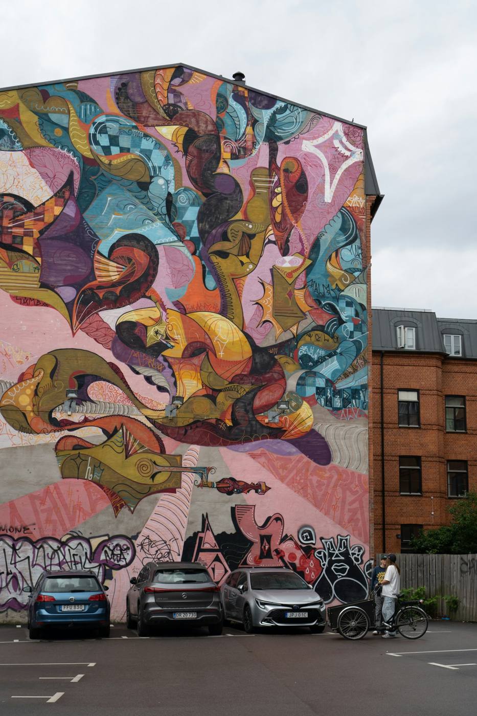 Mural de personajes en una fachada de ladrillo
