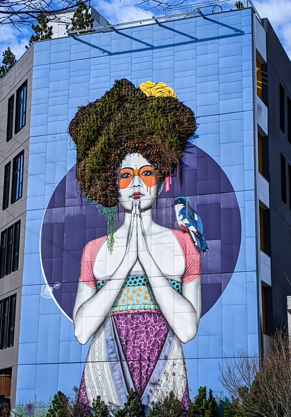 Mural de una mujer con flores en un edificio